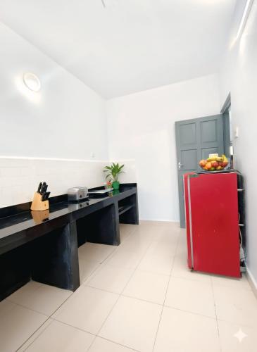 a kitchen with a red refrigerator in a room at Shraddha hospitality in Calangute