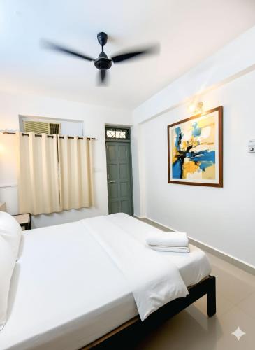 a bedroom with a bed and a ceiling fan at Shraddha hospitality in Calangute