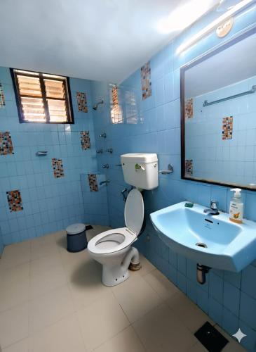 a blue bathroom with a toilet and a sink at Shraddha hospitality in Calangute