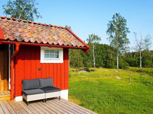 a red house with a bench on a deck at 5 person holiday home in Mellösa in Mellösa