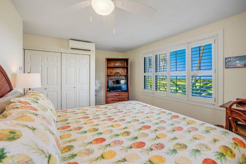 a bedroom with a bed and two windows at Condos in Kapaa in Kapaa