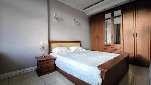 a bedroom with a large bed and a wooden cabinet at Уютная квартира в самом центре Пешая доступность in Chişinău