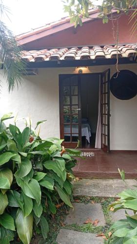 an open door to a house with a garden at Catavento Flats e Suítes in São Sebastião