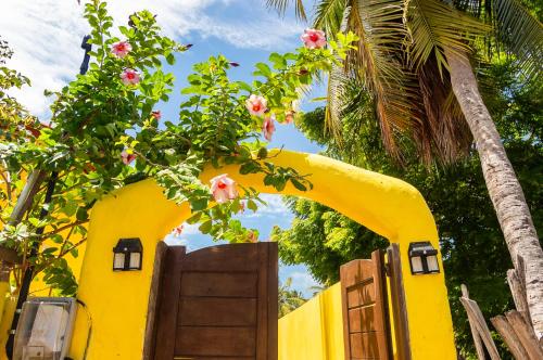 a yellow house with a door and a tree at Casa Amarela em Icaraí de Amontada in Amontada