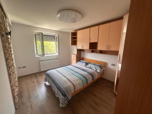 a small bedroom with a bed and a window at Apartment TINA in Spodnje Škofije