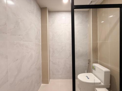 a bathroom with a toilet and a glass shower door at Serenova Hotel Siam Paragon, Bangkok in Bangkok