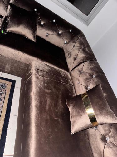 a brown leather couch with pillows on it at MandéHabitat in Bamako