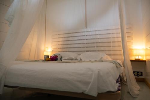 a bedroom with a white bed with a canopy at T1 Cosy la Kay émeraude-vue mer & surf-Tartane-Plage des surfeurs in La Trinité