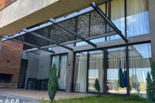 a building with a patio with glass windows at Villa N40 in Kachretʼi