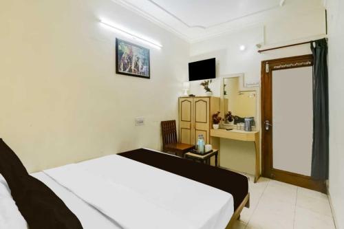 a bedroom with a bed and a desk in it at Super Hotel O Sindhi Camp Formerly Hotel Paul Avenue in Jaipur