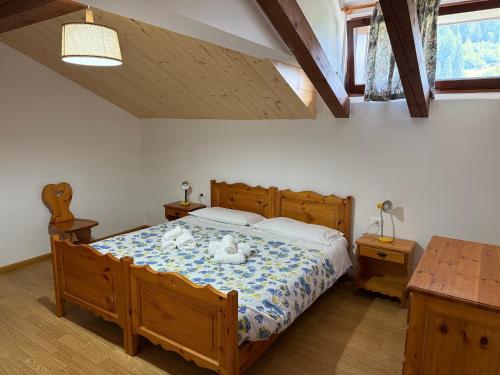 a bedroom with a bed with two swans on it at Mansarda Mulaz in Falcade
