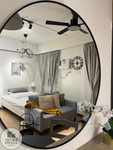 Un dormitorio con una cama, una silla y un espejo. en Deck&Dwell, en Trece Martires
