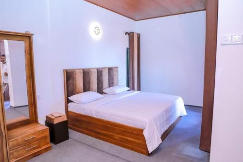 a bedroom with a large bed and a mirror at Villa de sunrise garden 