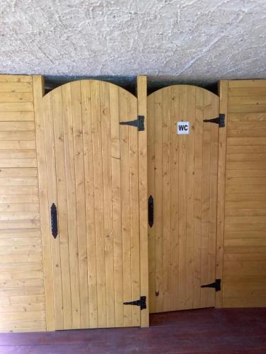 a pair of wooden doors in a room at Našio kempingas in Antanaše
