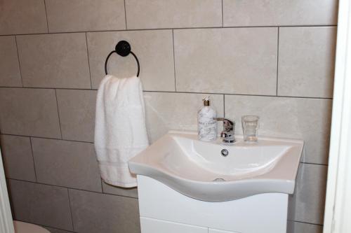 a bathroom with a white sink and a towel at The Boutique Bungalow in Bundoran