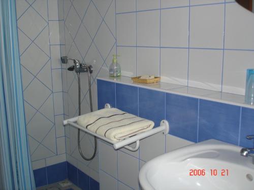 a blue tiled bathroom with a sink and a shower at Gîte des voyageurs in Vieux-Habitants