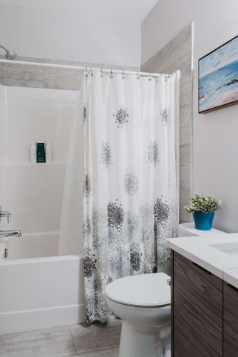 a bathroom with a toilet and a shower curtain at NordicSauna 3 Ensuite baths TheYellowDoorRetreat in Edmonton