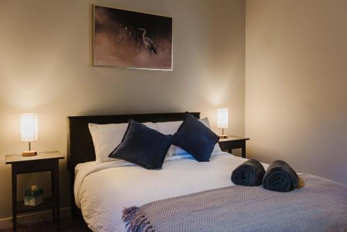 a bedroom with a bed with blue pillows and two lamps at NordicSauna 3 Ensuite baths TheYellowDoorRetreat in Edmonton