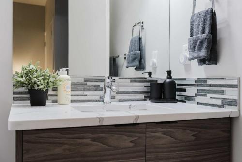 a bathroom with a sink and a mirror at NordicSauna 3 Ensuite baths TheYellowDoorRetreat in Edmonton