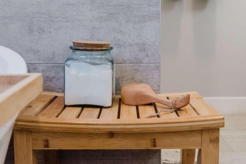 a mason jar sitting on a wooden table with a wooden spoon at NordicSauna 3 Ensuite baths TheYellowDoorRetreat in Edmonton