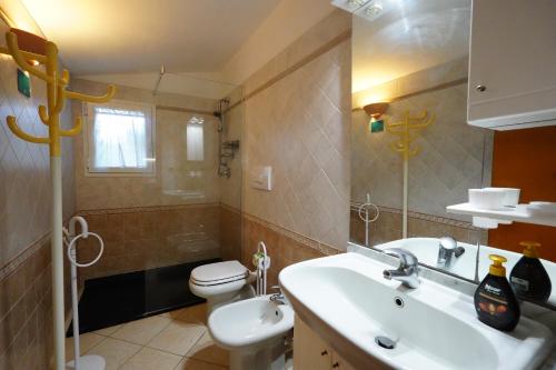 een badkamer met wastafel en toilet bij casaisoladelba immersa nel verde a 80mt dalla spiaggia in Lacona