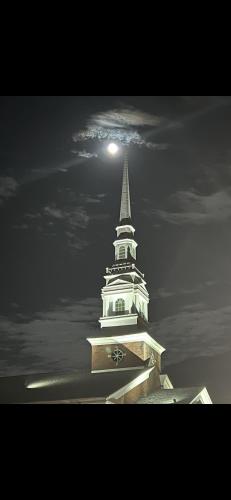 a white church steeple with a moon in the sky at Boone Trace Inn Room 2 in Pineville