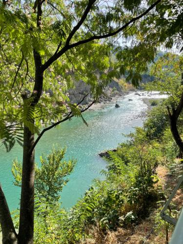a view of a river with trees in the foreground at Guesthouse Joal in Përmet