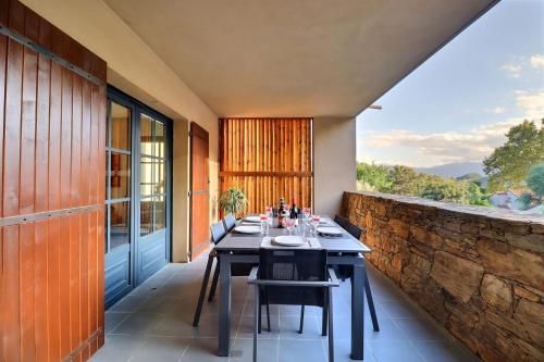 a dining room with a table and a stone wall at Rocca Bella Escape by the Sea and Vineyards in Patrimonio