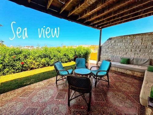 a patio with chairs and a table and a couch at Coastal Escape - Ballah Resort in El Hamam