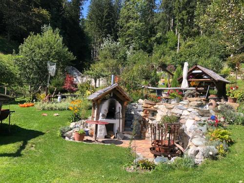 a garden with a stone fireplace in the grass at Wohnstudio in umgebauter Scheune in Altlassing