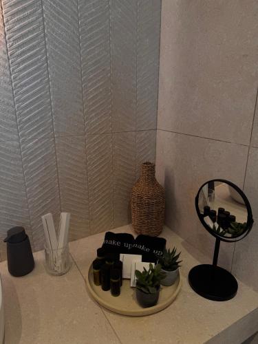 a table with a mirror and some plants on it at Marathon Coast-Seafront Luxury Apartments in Nea Makri