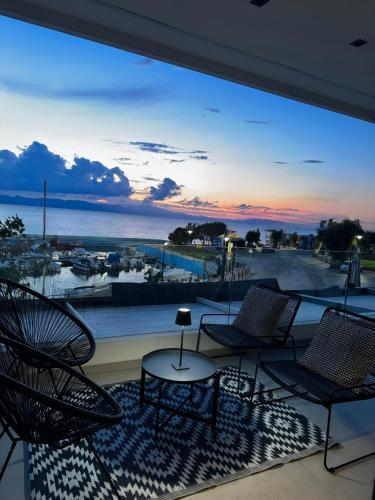 a balcony with chairs and a view of the ocean at Marathon Coast-Seafront Luxury Apartments in Nea Makri