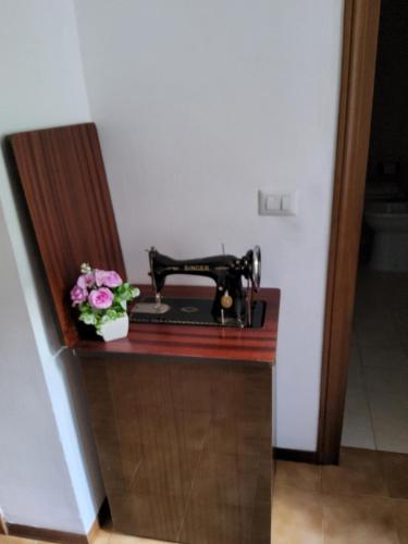 a table with a sewing machine and flowers on it at La casetta di monterivoso in Monterivoso