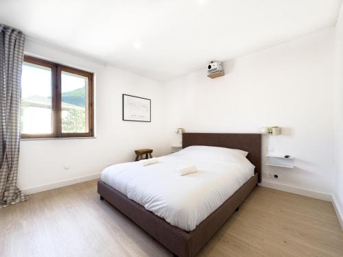 ブール・サン・モーリスにあるSki Cozy Bourg-Saint-Maurice Les Arcsの大きなベッドと窓のある寝室