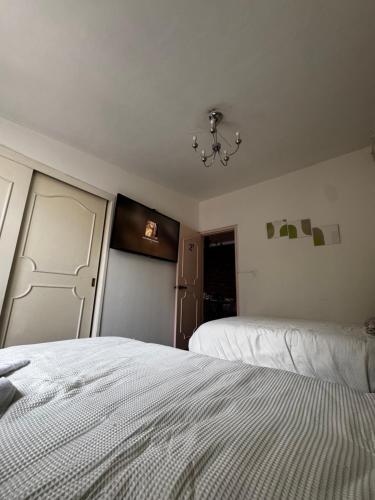 a bedroom with two beds and a chandelier at Casa Pascal in Toluca