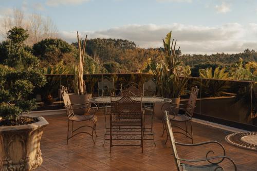 a patio with a table and chairs on a balcony at Hotel Leiriartem by Grupo Quinta dos Lagos in Leiria