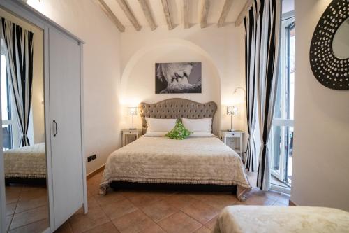 ein Schlafzimmer mit einem Bett und zwei Fenstern in der Unterkunft Santa Croce Garden Apartment in Florenz