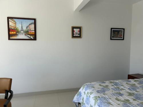a bedroom with three pictures on a white wall at Mar de Calafia 1 in Divisadero