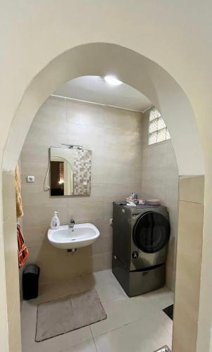 a bathroom with a sink and a tv in it at Spacious F3 in rouiba close to Algiers airport in Alger