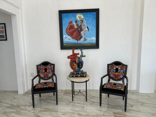 two chairs and a table with a painting on the wall at Mar de Calafia 1 in Divisadero