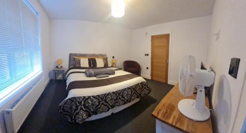 una camera da letto con un letto grande e una finestra di Newquay Beach Ocean Heights Villa a Newquay