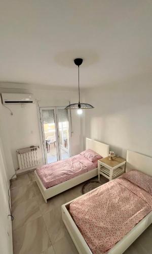 a bedroom with two beds and a table at Spacious F3 in rouiba close to Algiers airport in Alger