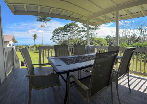 a patio with a table and chairs on a deck at Ocean View Ranch in Hilo