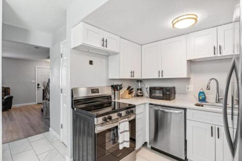 a kitchen with white cabinets and a stove top oven at All New! Convenient Location! Sleeps 6 in Denver