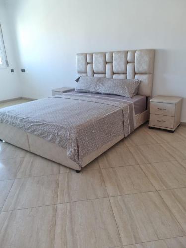a bedroom with a bed and a wooden floor at Bel appartement en plein Taza in Taza