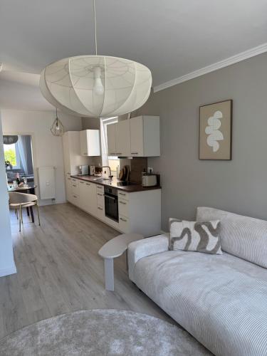 a white living room with a couch and a kitchen at Aesthetic Cozy Home Lüdenscheid in Lüdenscheid