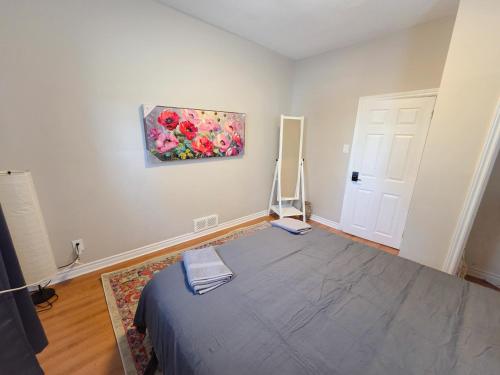 a bedroom with a bed and a painting on the wall at Byward Market Downtown Guesthouse in Ottawa