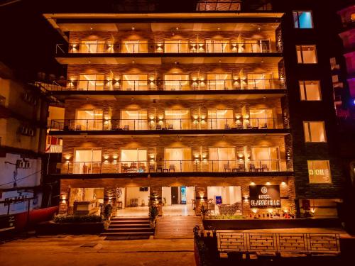 an apartment building with a balcony at night at Hotel Classic Hills Bhagsunag Luxury Stay #Best Hotel in Mcleodganj #Mountain View Balcony Rooms #Spacious Parking #Prime Location in Dharamshala #Near Bhagsunag Waterfall #Top Selling Property in Mcleodganj in Dharmsala