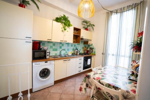 eine Küche mit einer Waschmaschine und einem Tisch in der Unterkunft Santa Croce Garden Apartment in Florenz