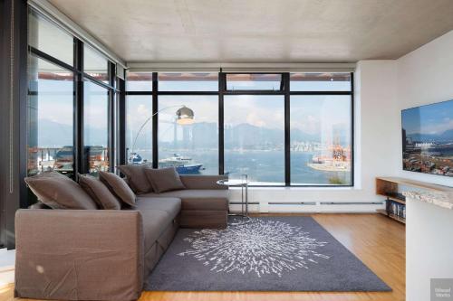 a living room with a couch and large windows at Spacious 2BD in Vancouver Patio with Ocean View in Vancouver